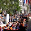 Orange boats in the Amsterdam canals at Queensday
