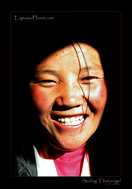 Smiling Tibetan girl coming out of the dark